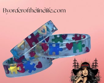 Pierścień z żywicy z elementami układanki i sercami, symbolizujący świadomość autyzmu