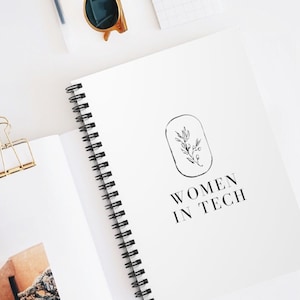 May include: A white spiral bound notebook with a black and white illustration of a plant and the text "Women in Tech".