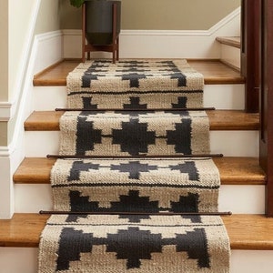 May include: A set of black and beige patterned stair treads with a geometric design. The treads are made of a woven material and are placed on wooden stairs.