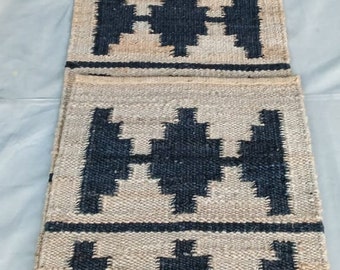 May include: A long, rectangular jute rug with a geometric pattern in black and white. The rug has a woven texture and is made of natural fibers.