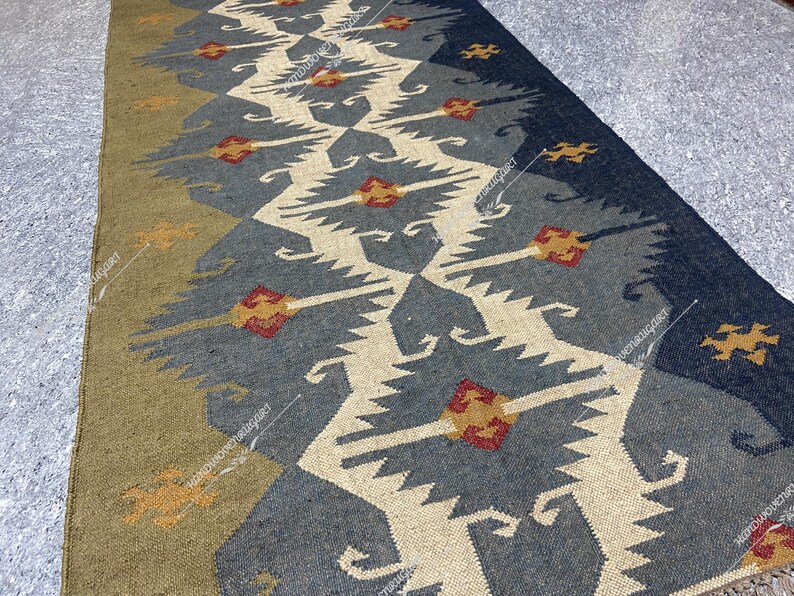 May include: A blue and beige patterned rug with a geometric design. The rug has a traditional, tribal look and is made of natural fibers.