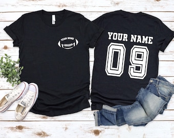 Könnte beinhalten: Zwei schwarze T-Shirts mit weißem Text und Grafiken. Ein Shirt sagt "Team Name" mit einer Football-Grafik. Das andere Shirt sagt "Your Name 09".