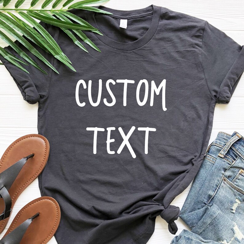May include: A charcoal gray t-shirt with the text "CUSTOM TEXT" printed in white.
