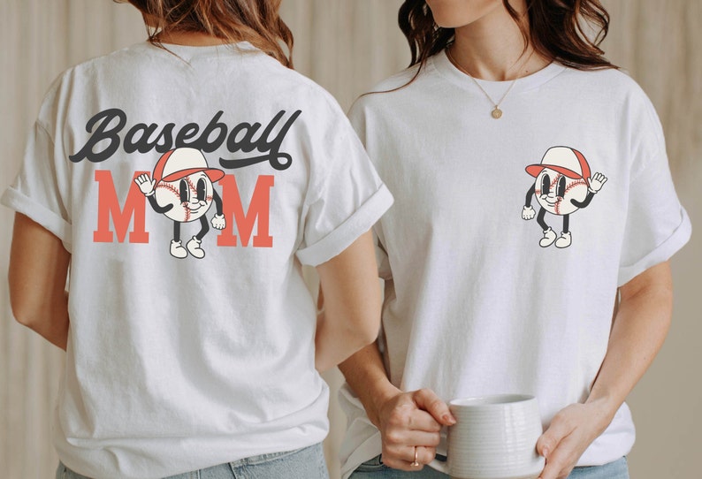 May include: White t-shirt with the text "Baseball Mom" in black and red lettering. A cartoon baseball with a red hat and a smiling face is in the center of the text.