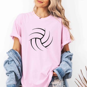 May include: A pink t-shirt with a black volleyball graphic.