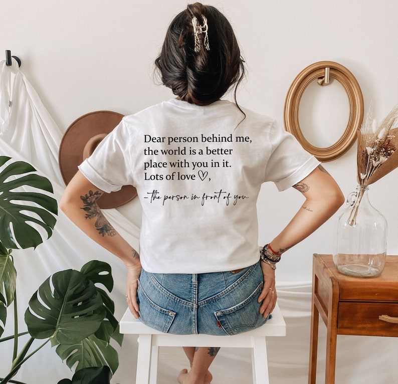 May include: White t-shirt with a message on the back that reads: "Dear person behind me, the world is a better place with you in it. Lots of love, -the person in front of you"