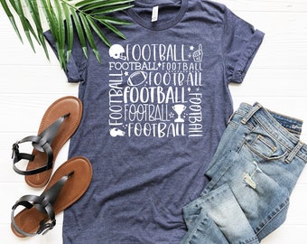 May include: A navy blue t-shirt with a white graphic design of the word "football" repeated multiple times in different sizes and orientations. The graphic also includes a football, a whistle, a trophy, and a raised hand with a pointing finger.