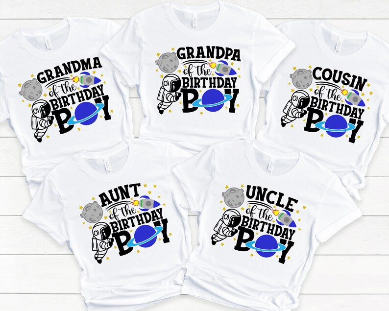 May include: Five white t-shirts with a space theme design. Each shirt features a different family member title, such as "Grandma of the Birthday Boy", "Grandpa of the Birthday Boy", "Aunt of the Birthday Boy", "Uncle of the Birthday Boy", and "Cousin of the Birthday Boy".
