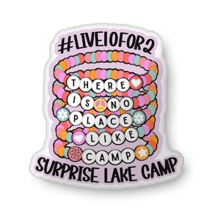 May include: A sticker with a stack of colorful beaded bracelets. The bracelets have white letter beads that spell out "THERE IS NO PLACE LIKE CAMP" and the words "SURPRISE LAKE CAMP" at the bottom. The sticker also has the text "#LIVEIOFOR2" at the top.