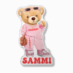 May include: A cartoon teddy bear wearing sunglasses, a pink sweatsuit with "CHENNY" and "18427" printed on it, and pink sneakers. The bear is holding a drink and a brown purse. The word "SAMMI" is printed in red at the bottom.