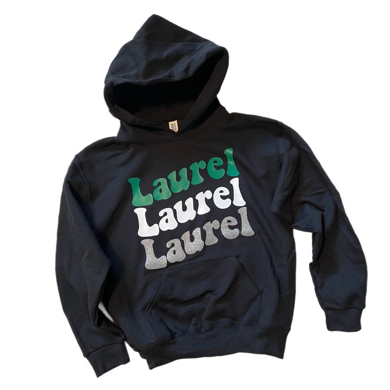 May include: Black hooded sweatshirt with the word "Laurel" repeated three times in green, white, and silver glitter lettering.