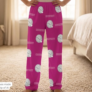 May include: Bright pink pajama pants featuring an all-over repeating pattern of white volleyballs and the name Courtney printed in a white sans-serif font. The pants have an elastic waistband and a loose, straight-leg fit for comfortable wear.
