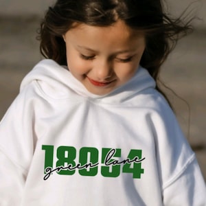 May include: White hooded sweatshirt with a green graphic print that says "green lane 1804".