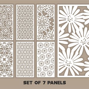 Könnte beinhalten: Set aus sieben weißen Dekorplatten mit aufwendigen floralen und geometrischen Ausschnitten. Die Paneele weisen verschiedene Muster auf, darunter Gänseblümchen, Sternausbrüche und sich wiederholende geometrische Formen. Der Text "SET OF 7 PANELS" ist unten zu sehen.