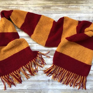 May include: A red and gold striped knitted scarf with long tassels.