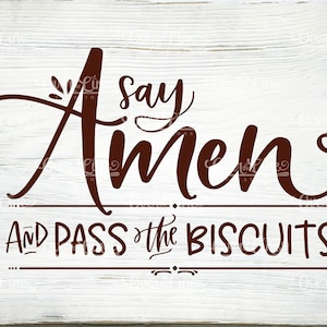 Könnte beinhalten: Ein weißes Holzschild mit braunem Text, auf dem "Say Amen and Pass the Biscuits!" steht.