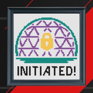May include: Cross-stitch pattern featuring a purple and teal dome with a yellow padlock in the centre. The text "INITIATED!" is below the dome.