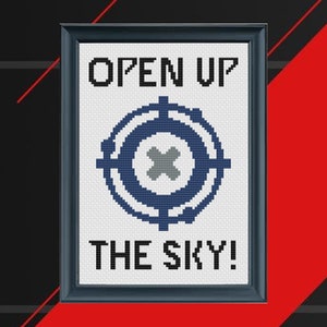 May include: Cross-stitch pattern with a blue and gray target symbol and the text "OPEN UP THE SKY!" in a black frame.