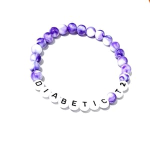 May include: Purple and white beaded bracelet with the word "DIABETIC T2" spelled out in white beads.