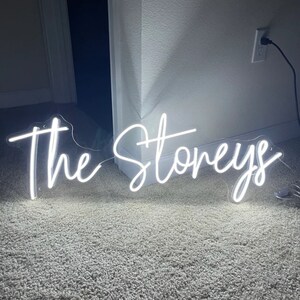 Puede incluir: Letrero de ne&oacute;n blanco con el texto "The Stoneys" en una fuente cursiva.