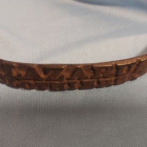 May include: A rusty metal handle with a decorative design and the words "C.W. MILLER & CO. PAT. APPL'D FOR" embossed on the surface.