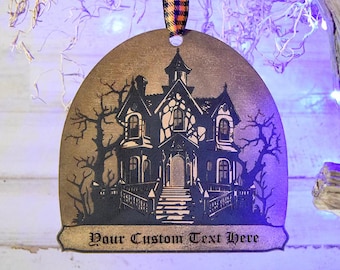 May include: A Halloween-themed ornament featuring a haunted house silhouette with the text "Your Custom Text Here." The ornament is suspended by a plaid ribbon. The house is black and the background is gold.