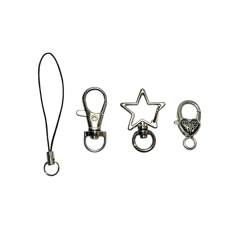 May include: A selection of silver metal clasps and a black lanyard. The clasps include a lobster claw, a star-shaped clasp, and a heart-shaped clasp. The lanyard has a small metal ring. Suitable for attaching to keychains, bags, or other accessories.