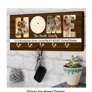 May include: A wooden key holder with the word "HOME" spelled out in large letters. Each letter has a photo of a family inside. The key holder has four hooks and a small map with a red heart marking a location. The text "The Smith Family" and "1210 Brookgreen Drive, Louisville KY 40243, United States" is printed below the photos.