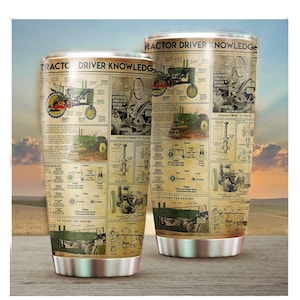 Op de afbeelding: Twee roestvrijstalen bekers met een vintage ontwerp over tractorbestuurderskennis. Het ontwerp toont een groene tractor met gedetailleerde illustraties en tekst over de bediening en de motor van de tractor.