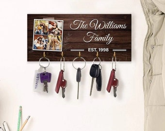 May include: A wooden key holder with a photo of a family and the text "The Williams Family Est. 1998". There are five keys hanging on hooks.