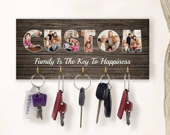 May include: A wooden key holder with the word "CUSTOM" spelled out in photos of a family. The text "Family Is The Key To Happiness" is written below the photos. There are six hooks on the holder with keys hanging from them.