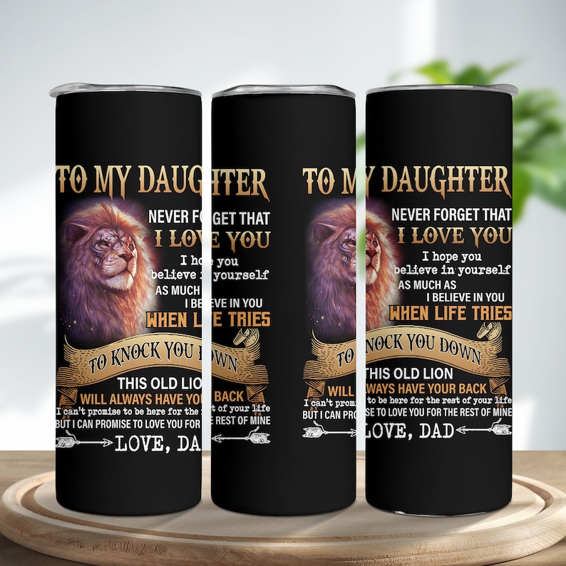 May include: Black insulated tumbler with a lion illustration and text that reads "TO MY DAUGHTER, NEVER FORGET THAT I LOVE YOU." The tumbler has a black background and a silver rim. The text also includes "LOVE, DAD."