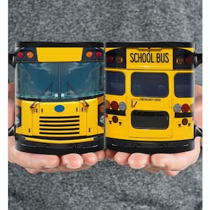 May include: Two black mugs with a yellow school bus design. One mug shows the front of the bus and the other shows the back of the bus. The back of the bus has the words "SCHOOL BUS" printed on the back.