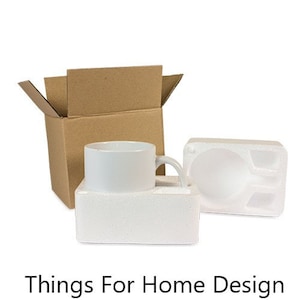 May include: A white ceramic mug is packaged in a brown cardboard box with a white styrofoam insert. The mug has a handle and is ready to be shipped.