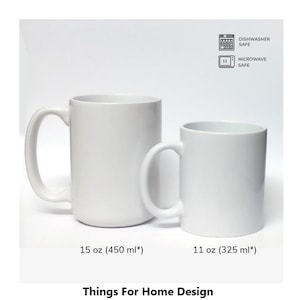Op de afbeelding: Twee witte keramische mokken, een van 15 ounce en een van 11 ounce, met pictogrammen die aangeven dat ze vaatwasser- en magnetronbestendig zijn. De mokken staan op een witte achtergrond.