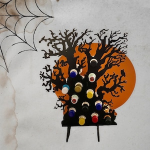 May include: Black metal Halloween tree silhouette with a spooky orange moon background. The tree has 16 bottle holders with colorful bottle caps.