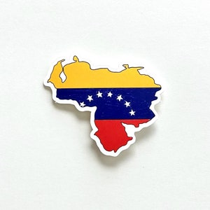 May include: A sticker of the outline of Venezuela with the Venezuelan flag colours: yellow, blue, and red. The flag has seven white stars in an arc.