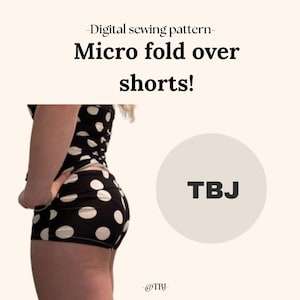 Könnte beinhalten: Digitales Schnittmuster für Micro-Fold-Over-Shorts. Die Shorts sind schwarz mit großen weißen Punkten. Das Bild enthält auch den Text "TBJ" in einem hellbeigen Kreis.