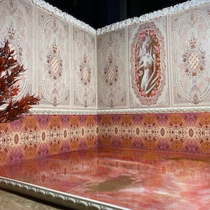 Könnte beinhalten: Ein Miniatur-Raumset mit weißen Wänden mit verzierten Mustern und einem rosafarbenen gemusterten Boden. Die Wände sind mit einem gekräuselten weißen Besatz verziert. Der Raum hat einen rosafarbenen Boden mit einem weißen Rand.