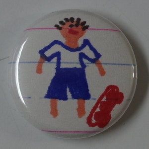 Puede incluir: Un botón blanco con un dibujo de una persona que lleva una camisa azul y blanca y un pantalón rojo. La persona está de pie sobre un fondo blanco con líneas rosas.