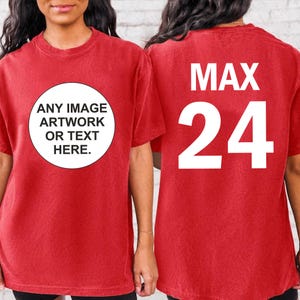 Peut inclure: T-shirt rouge avec un cercle blanc sur le devant qui dit "ANY IMAGE ARTWORK OR TEXT HERE." Le dos du t-shirt a du texte blanc qui dit "MAX 24".