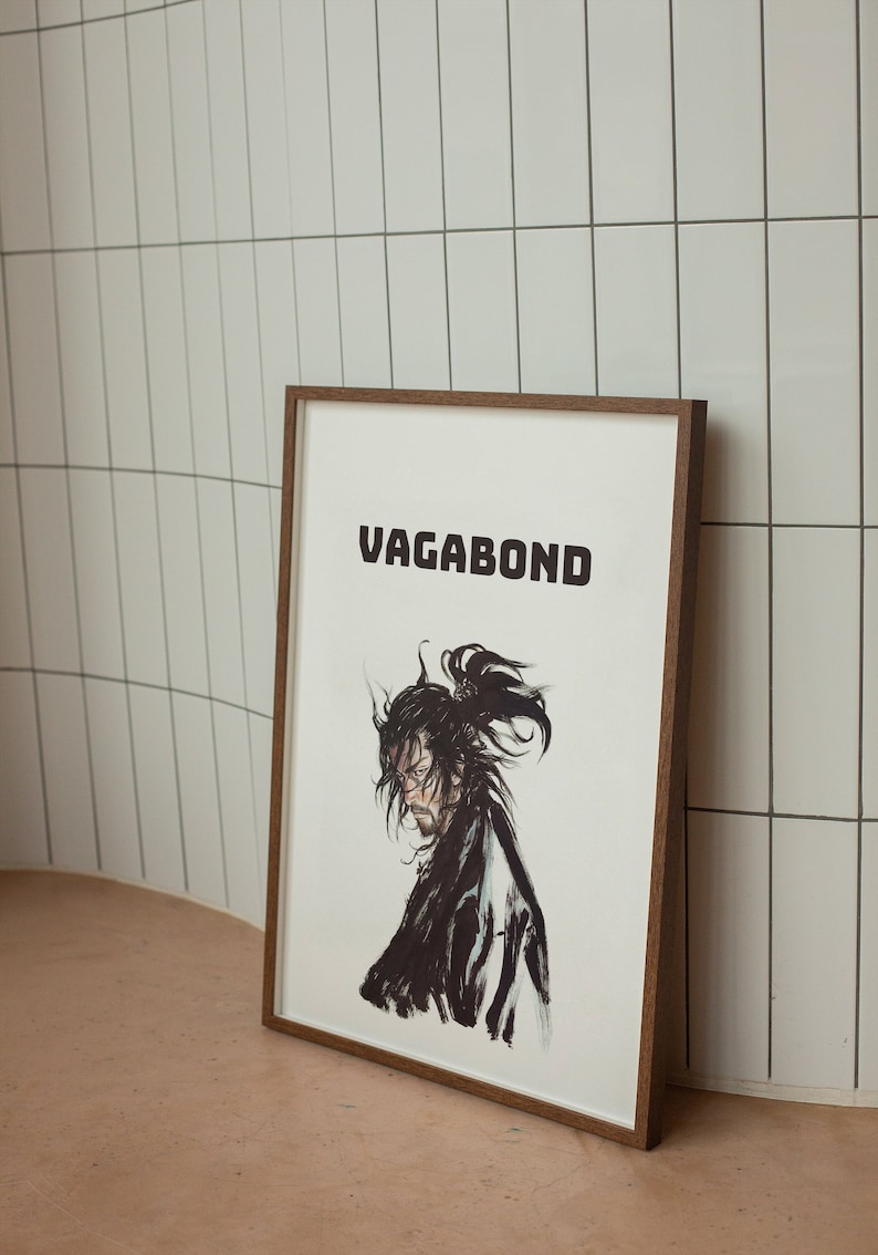 May include: A framed print with a black and white illustration of a samurai warrior with the word "VAGABOND" in bold black letters at the top.