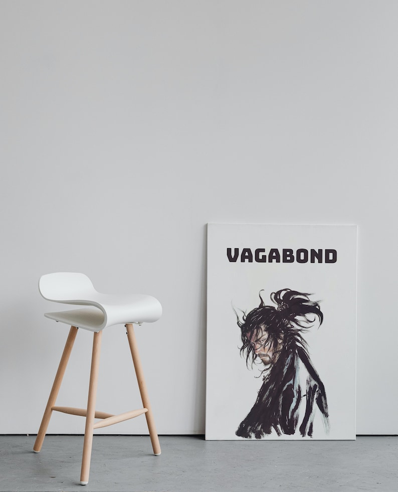 May include: A white wooden bar stool with a white, curved seat and a black and white poster with the word "VAGABOND" and a black and white illustration of a person with long hair.