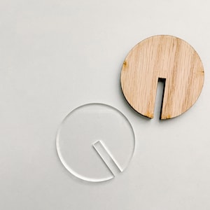 May include: Two round, blank, unfinished wood and acrylic circles with a vertical slot cut out of the center of each.