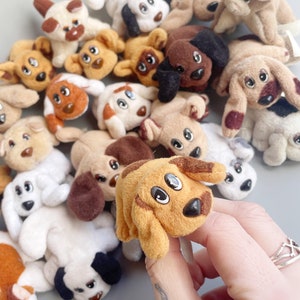 Op de afbeelding: Een verzameling pluche honden in verschillende kleuren en poses. De honden hebben grote ogen en zijn gemaakt van zacht, pluche stof.