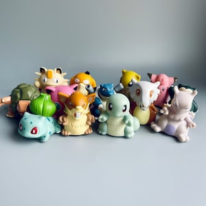 May include: A collection of 14 colourful Pokemon figurines, including Bulbasaur, Charmander, Squirtle, Pikachu, and more. The figurines are made of plastic and are in good condition.
