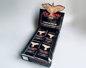 May include: A black box of The Crow trading cards. The box features a crow graphic and the text "The Crow: City of Angels." The box contains 8 packs of cards, each with 1 dated for pain and 1 card for fun.