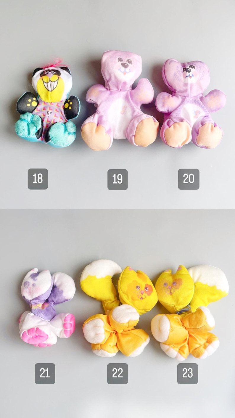 Pu&ograve; includere: Una collezione di peluche con vari disegni di animali. I giocattoli includono un panda, orsi e gatti, ognuno con combinazioni di colori e tratti del viso unici. I numeri 18, 19, 20, 21, 22 e 23 sono stampati sotto ogni giocattolo.