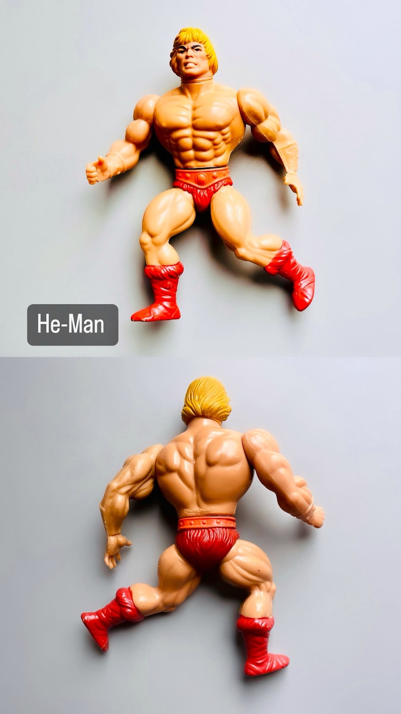 May include: A vintage He-Man action figure with a muscular build, blond hair, and a red loincloth. The figure is posed in a running stance with both legs bent and feet raised. The figure is wearing red boots with fur trim.