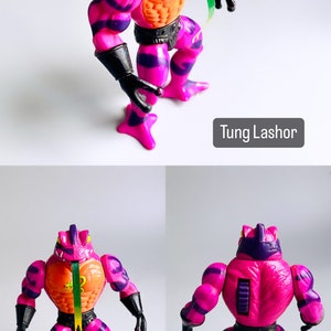 May include: A pink and purple action figure of Tung Lashor from the Masters of the Universe toy line. The figure has a frog-like head with a long tongue and a muscular body with a black belt. The figure is posed in a standing position with its arms outstretched.